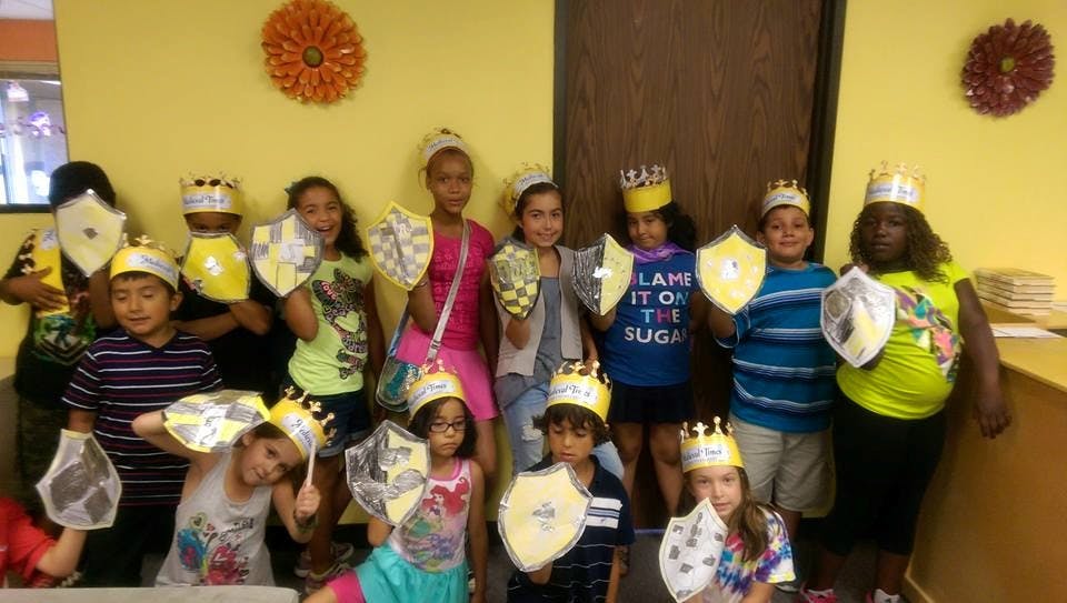 Group of children wearing crowns and holding shields