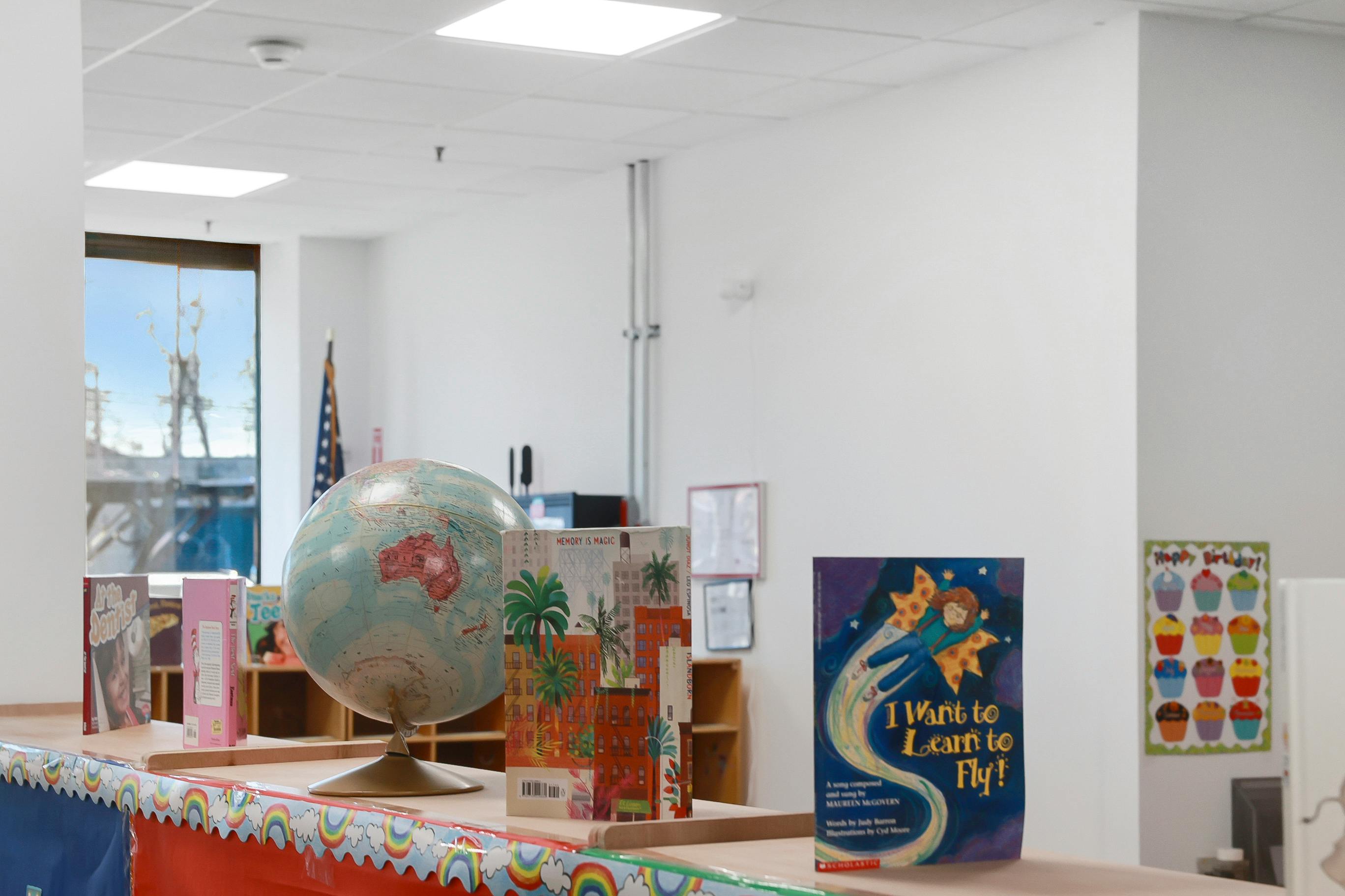 Globe and children's books on a library shelf