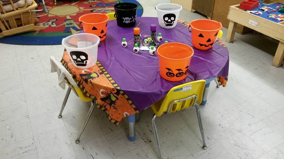 Table with purple tablecloth and Halloween-themed buckets