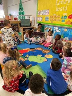 Adult reading to children in a classroom