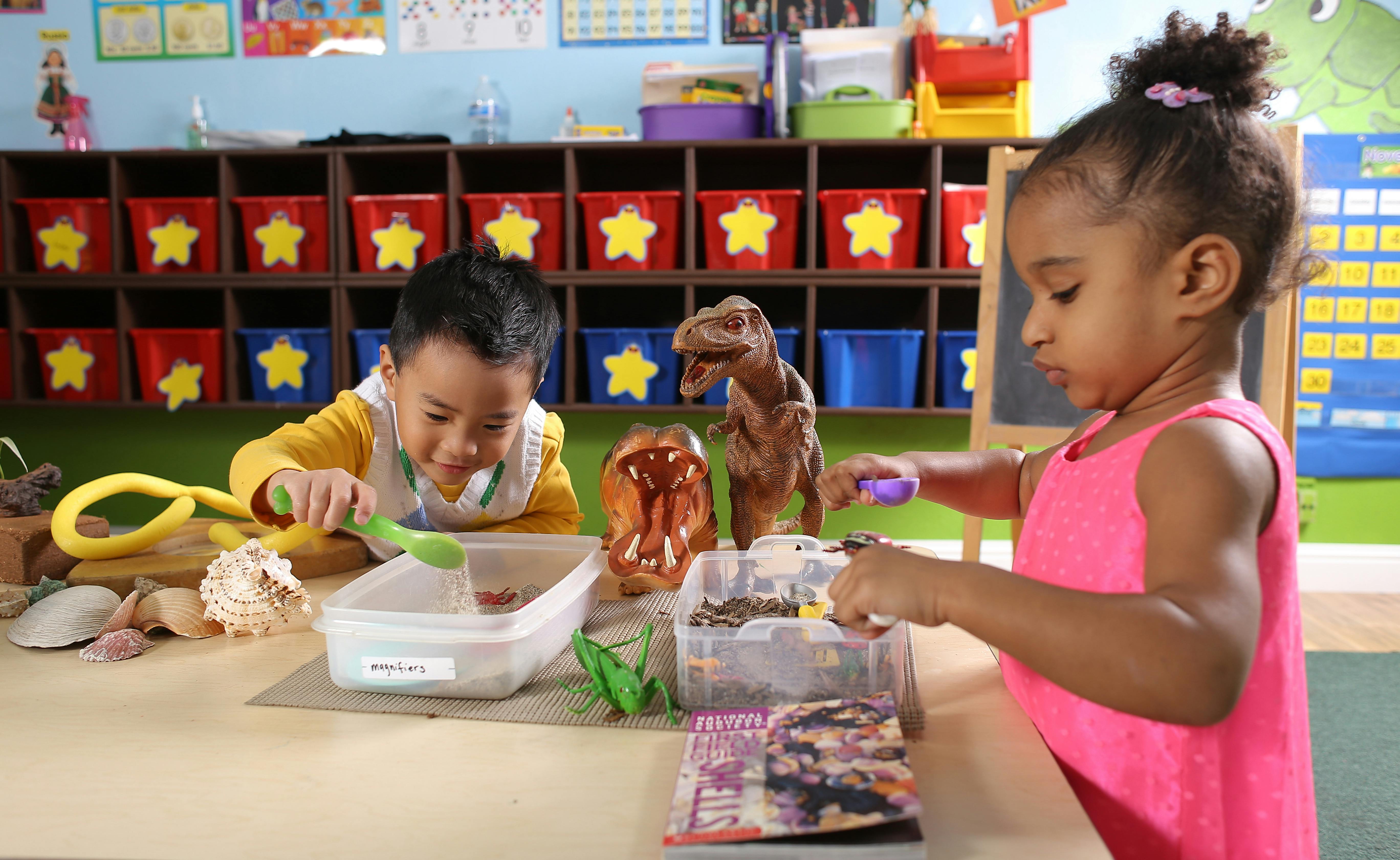 Two children playing with toys at a table