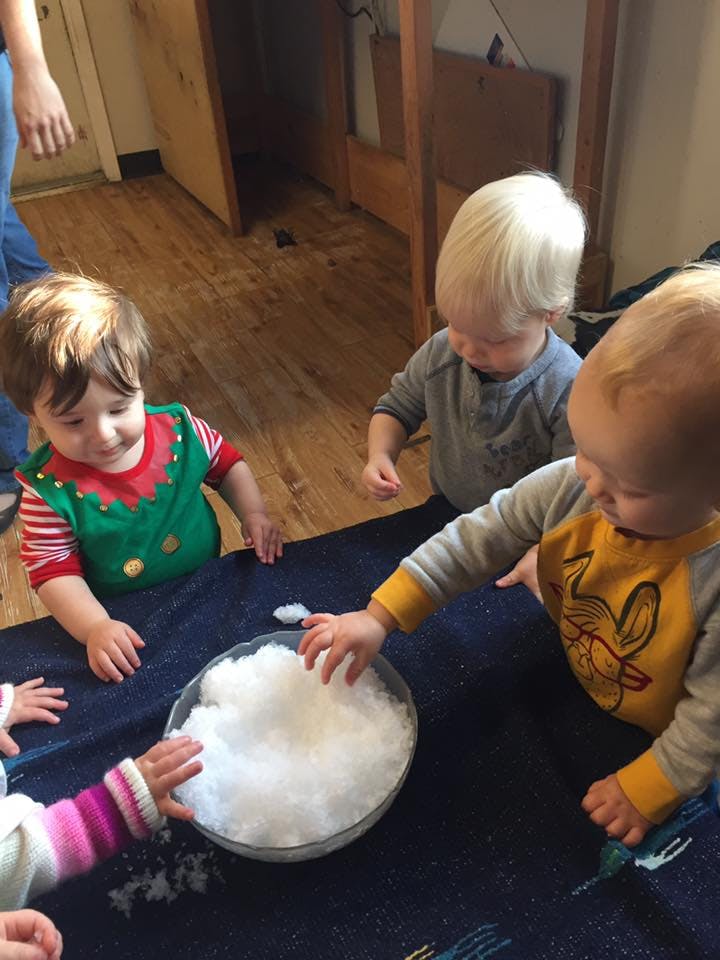 Children playing with snow in a bowl