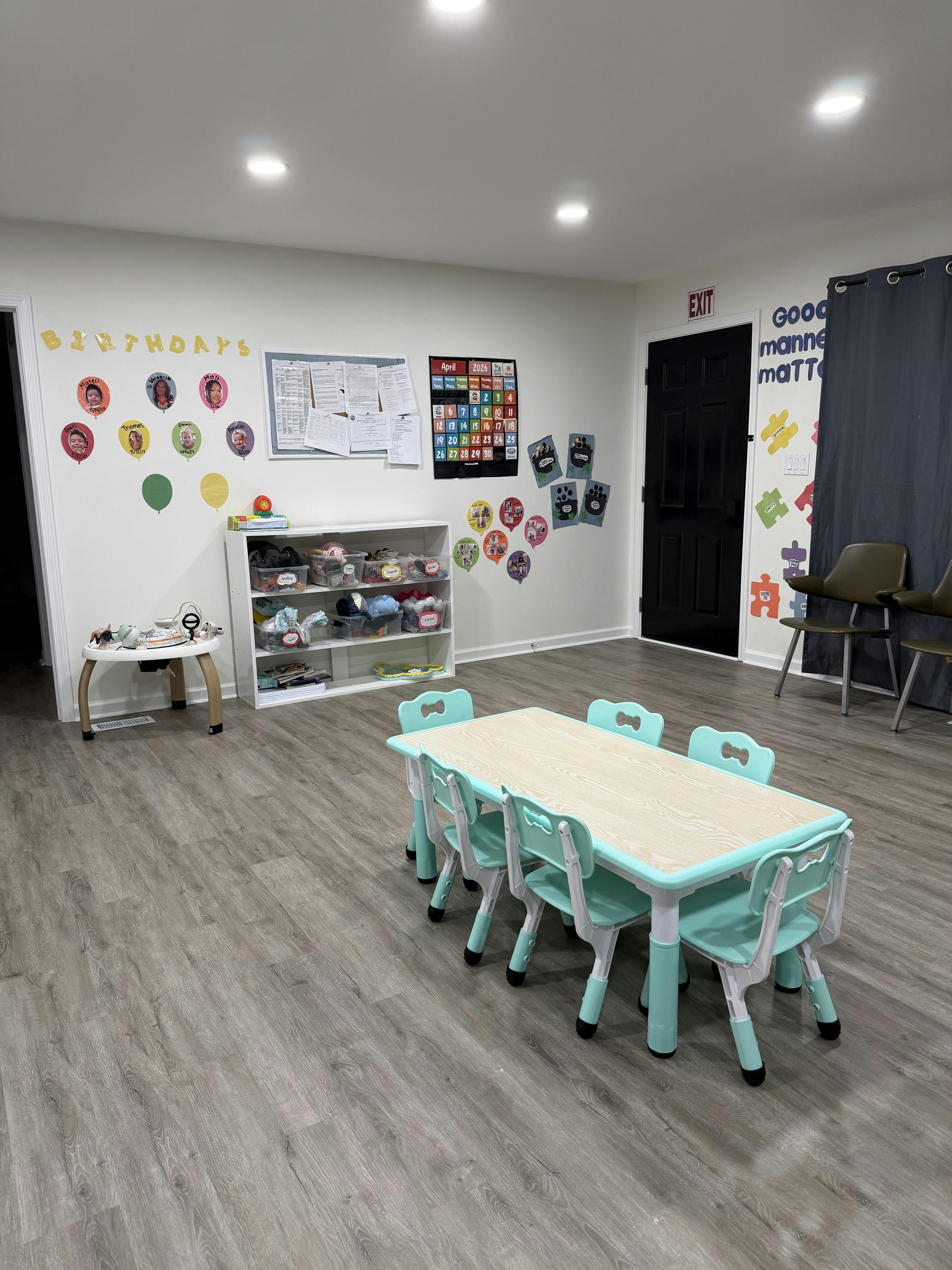 Small table and chairs in a classroom with birthday decorations on the wall