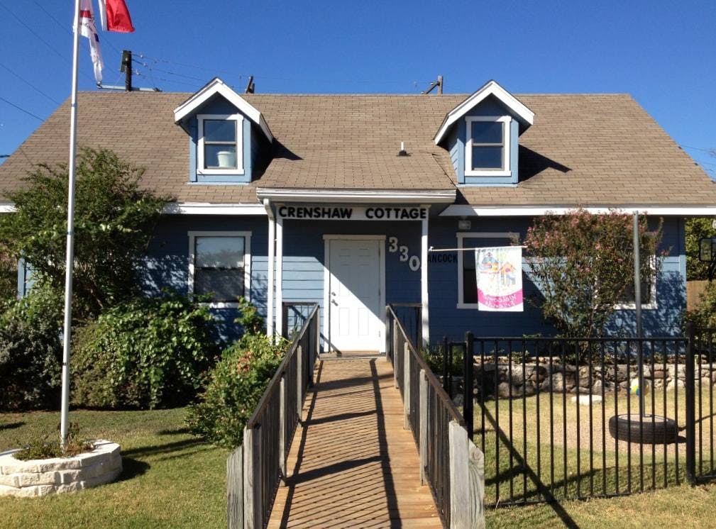 Blue house with a brown roof and a ramp leading to the front door