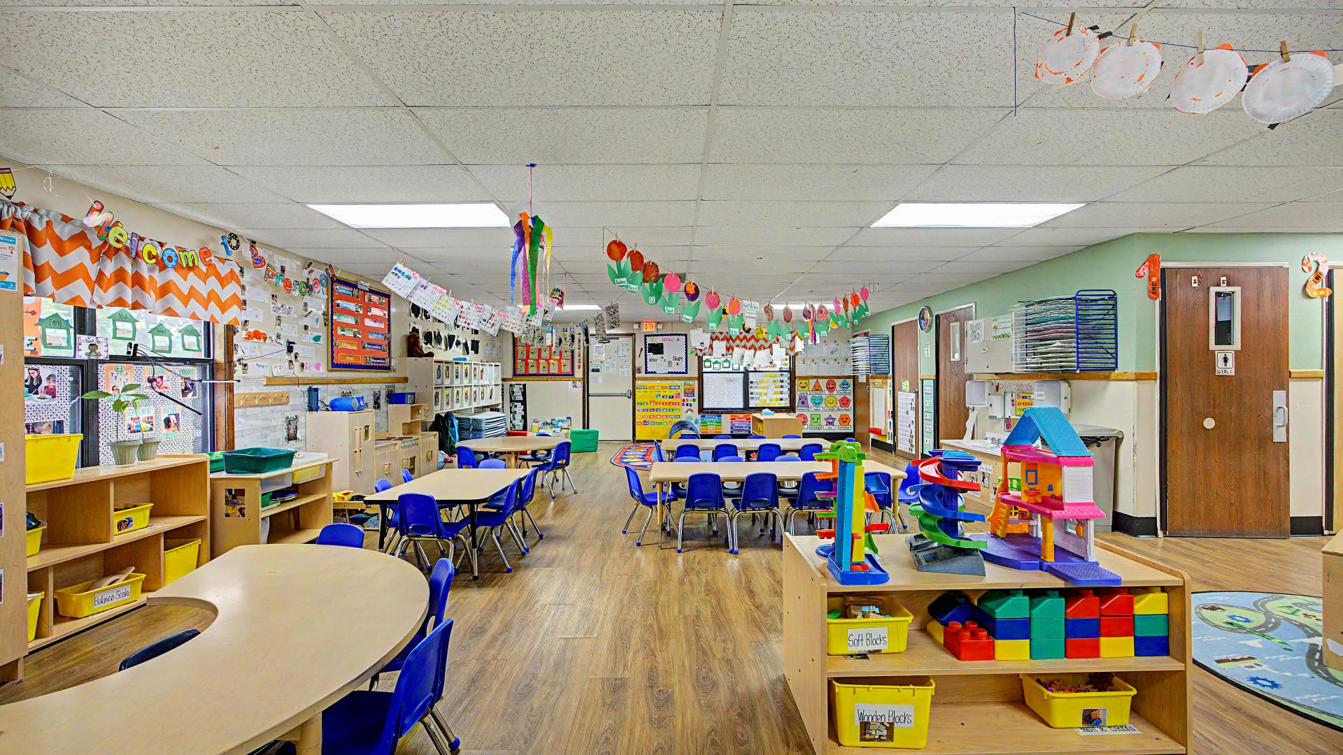 Colorful and decorated preschool classroom with tables and chairs