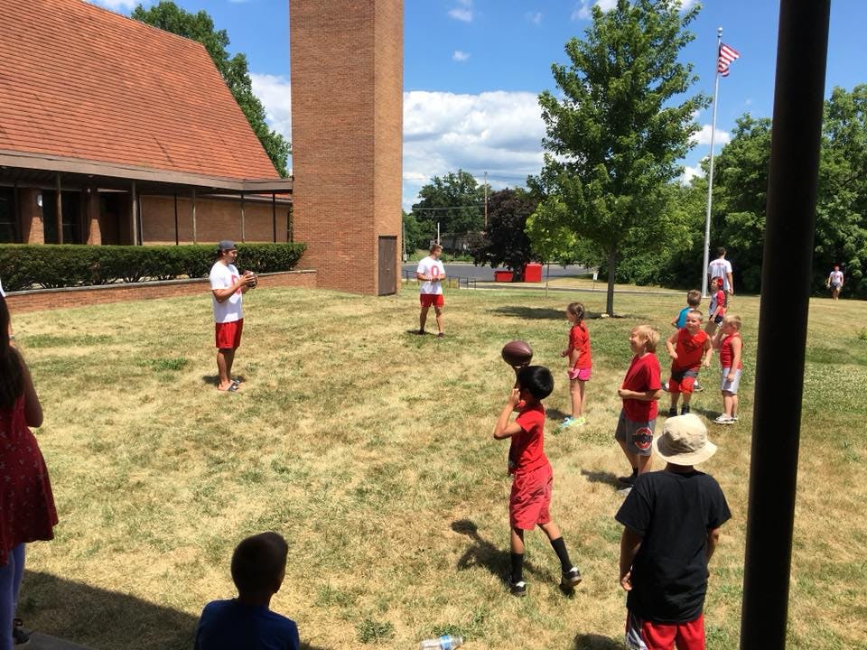 People and children playing with footballs outdoors