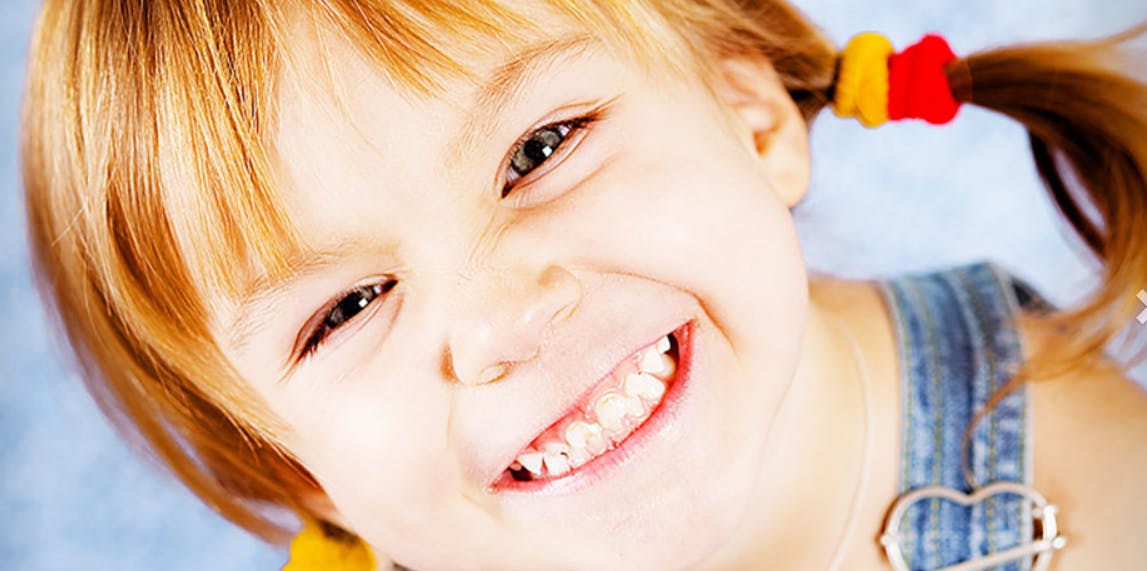 Child with pigtails smiling