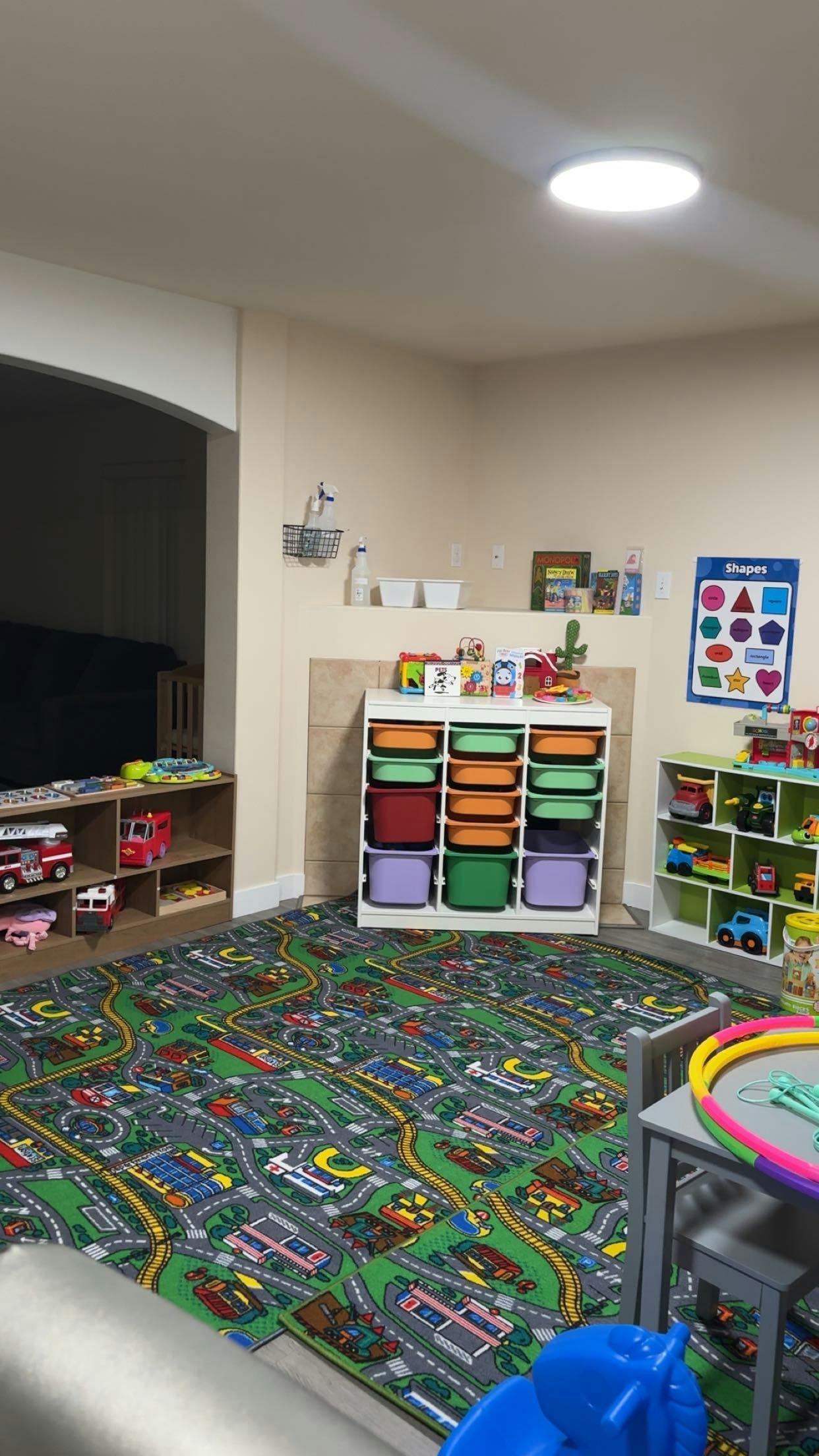 Playroom with storage shelves, toy vehicles, and a road-themed rug