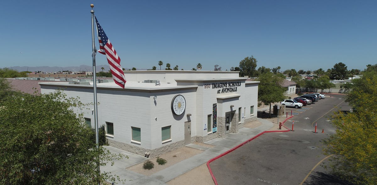 American flag on a pole in front of a white building