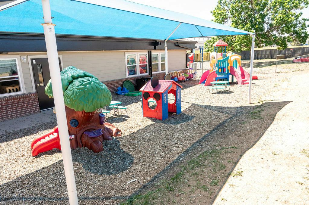 Playground equipment under a blue shade structure