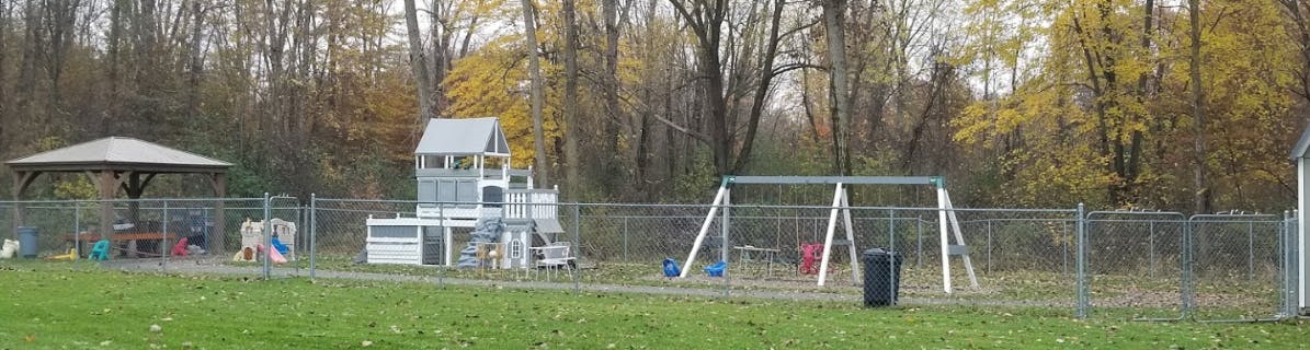 Playground with swings, a playhouse, and a covered picnic area