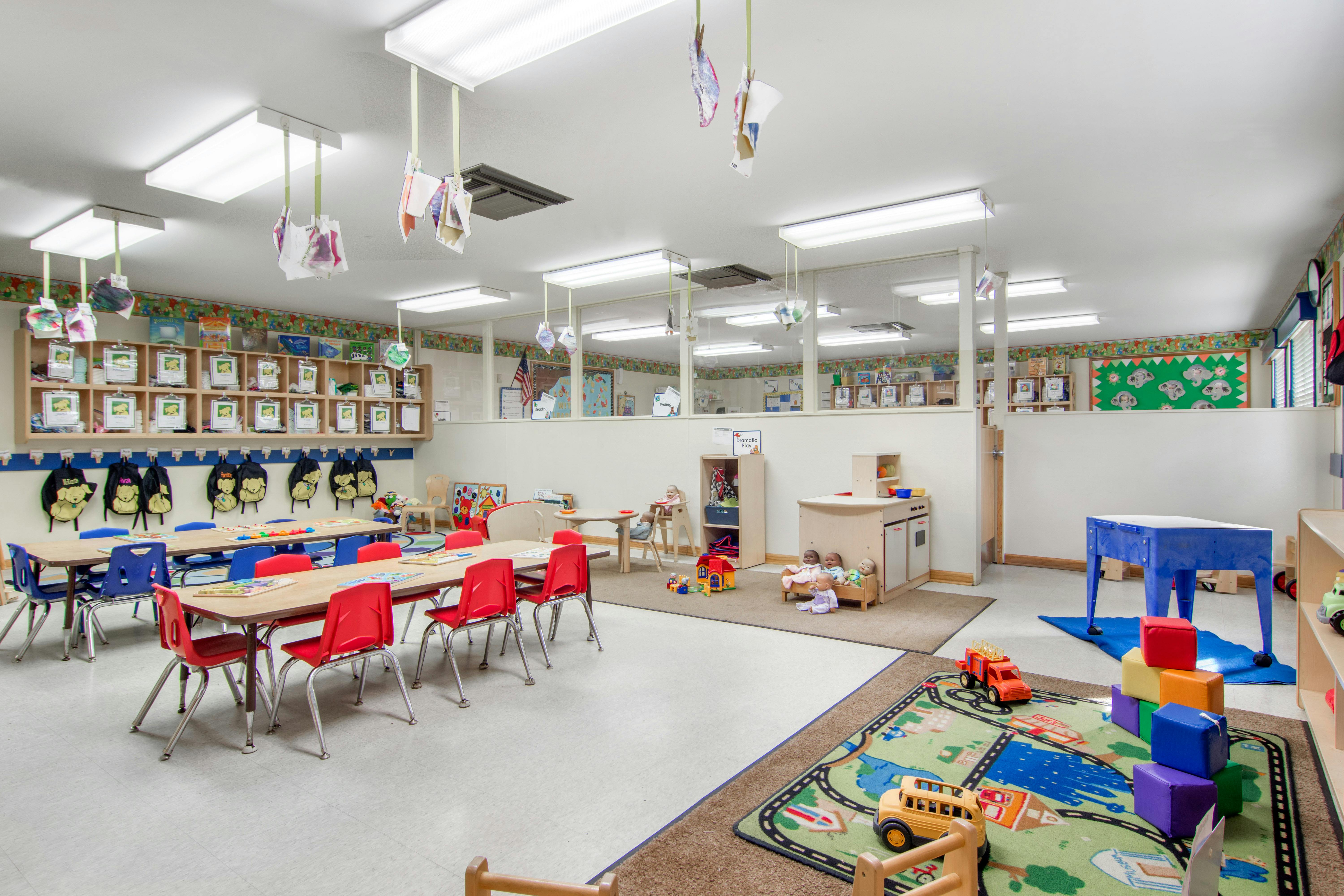 An empty early childhood classroom with colorful furniture and toys