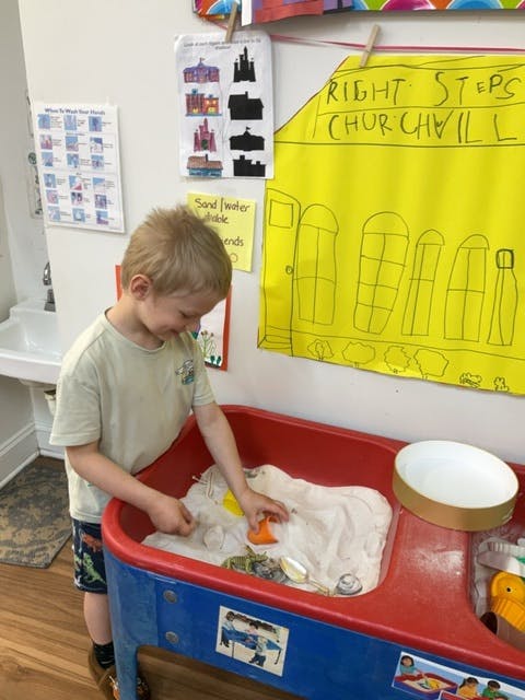 Child playing in a sand and water table