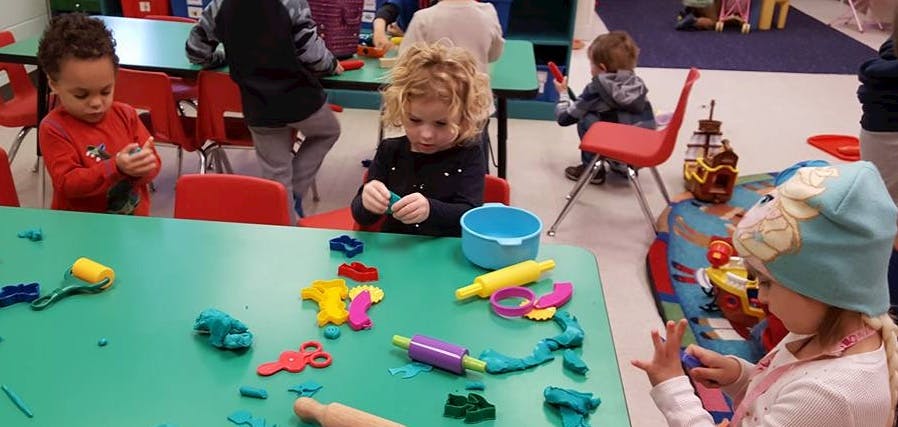 Children playing with modeling clay at a table
