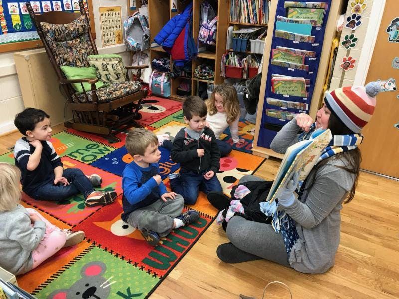 Adult reading to children in a classroom