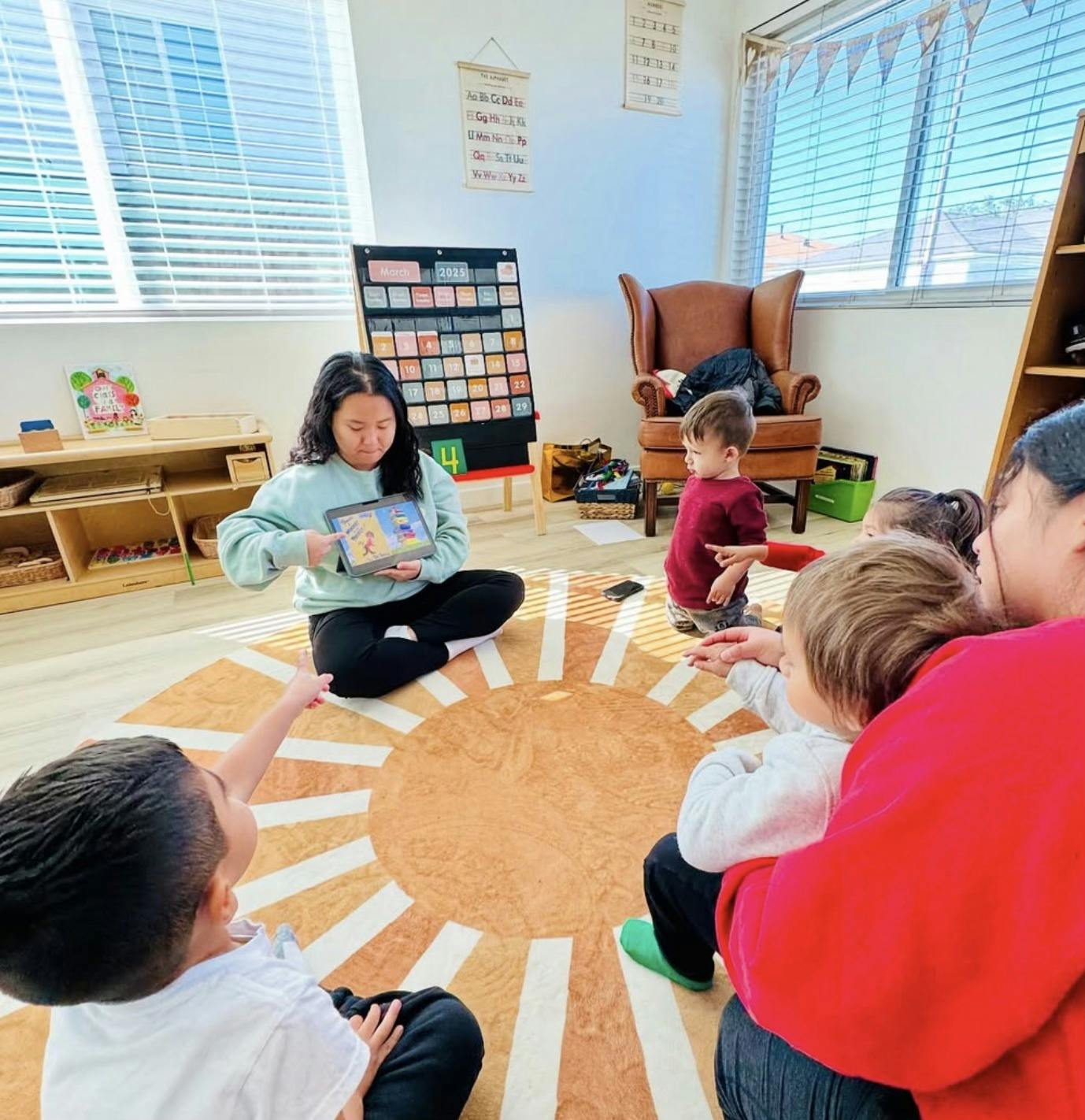 Person showing a tablet to children in a classroom