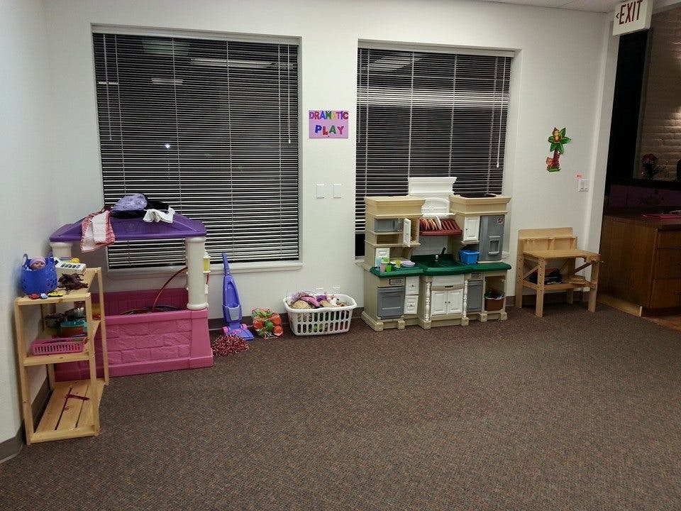 Children's play area with toy kitchen, table, and shelves