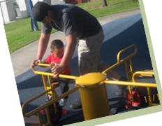 Adult and child on a playground ride