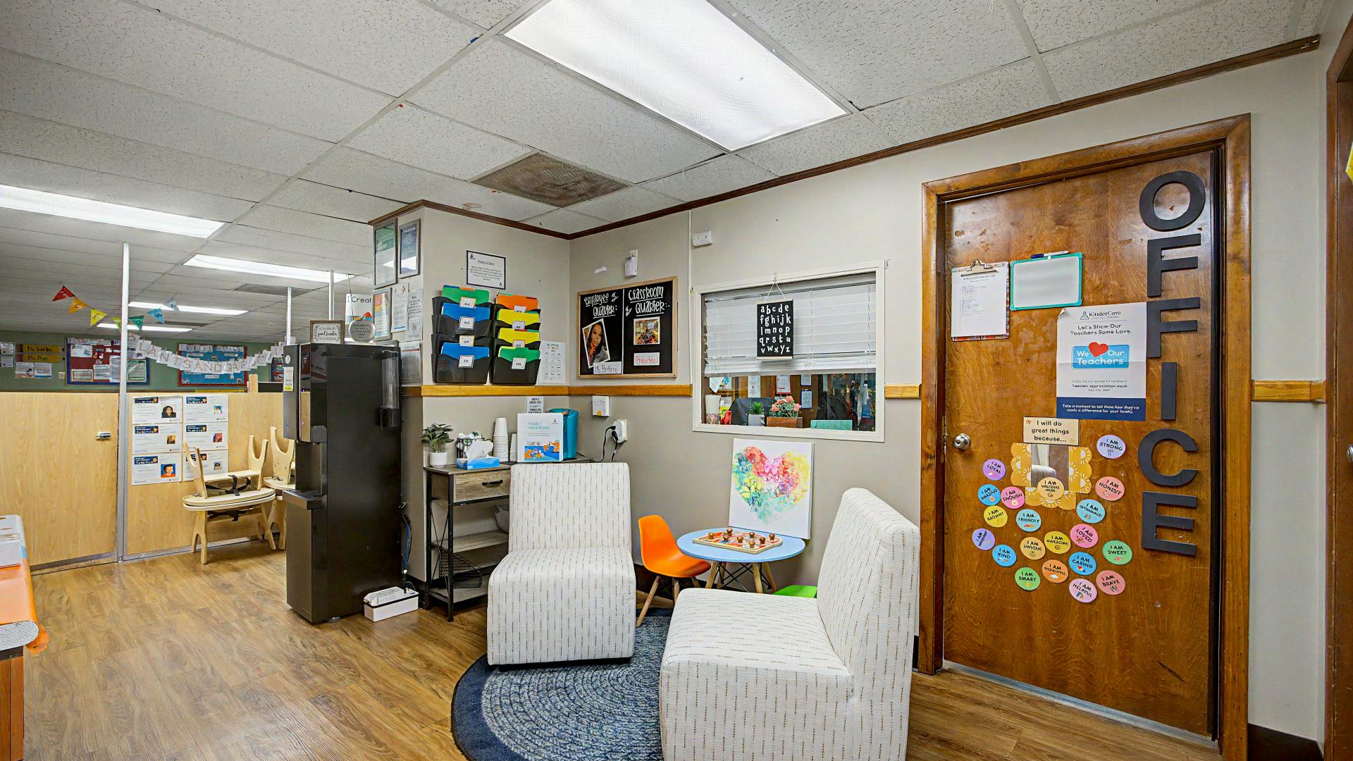An office waiting area with two armchairs, a small table, and an office door