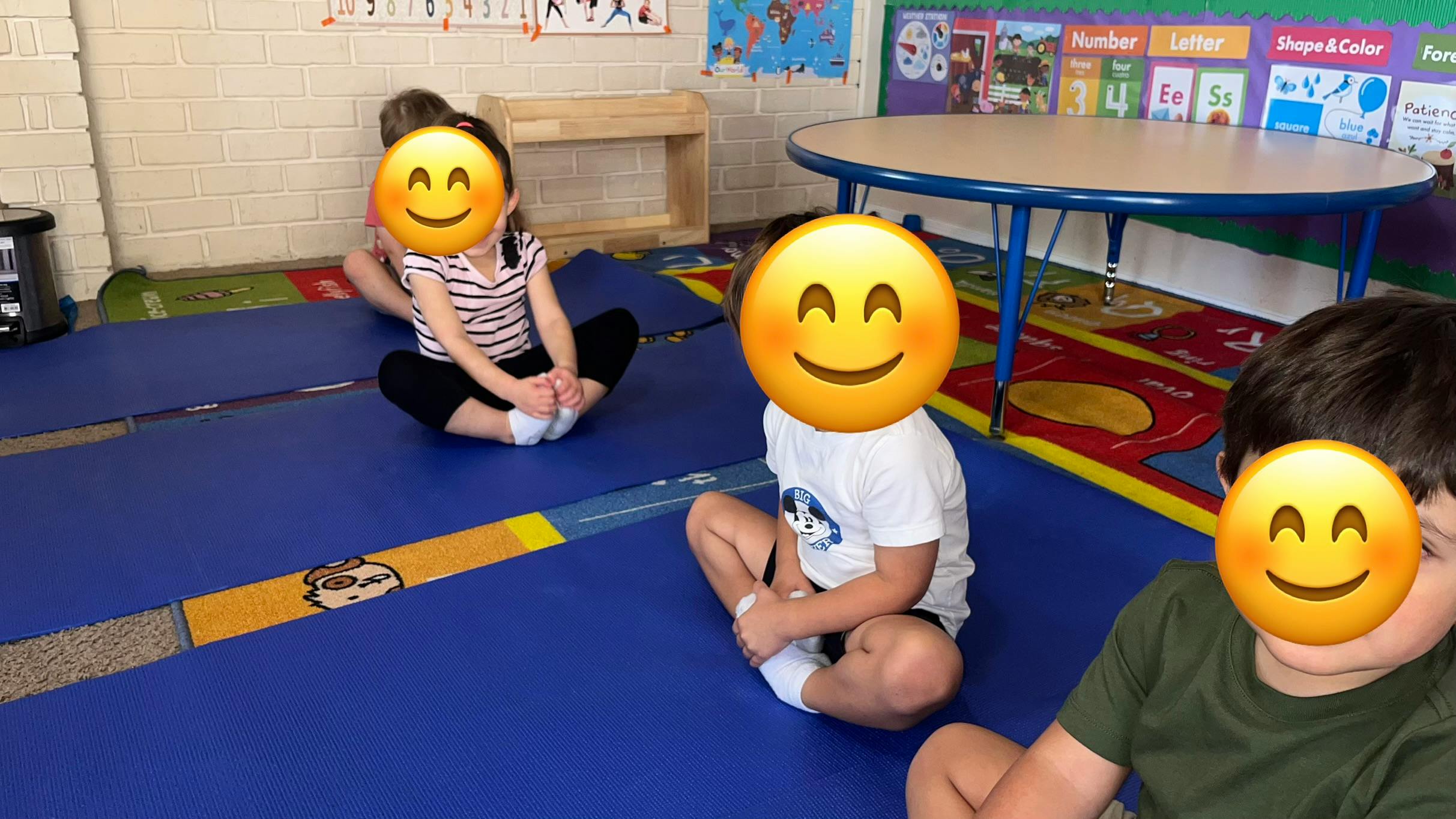 Children sitting in a circle on mats in a classroom