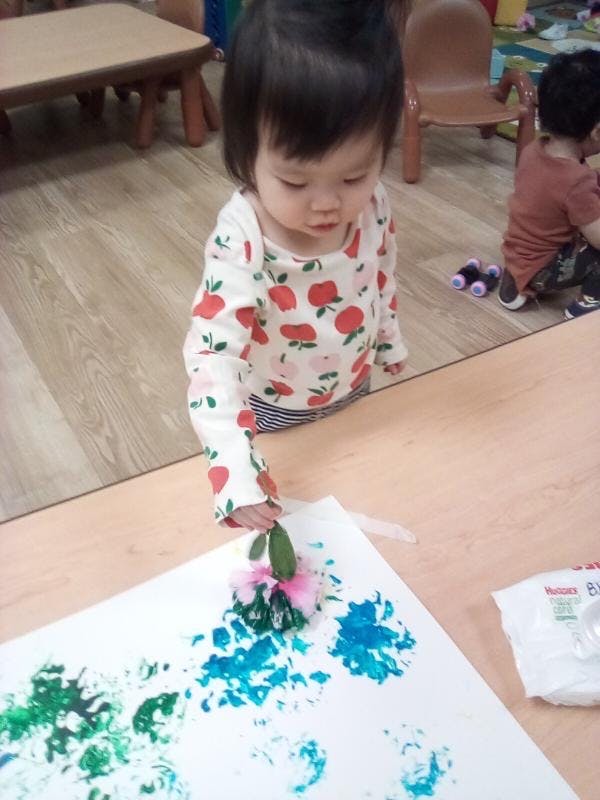 Child making art with paint and natural materials