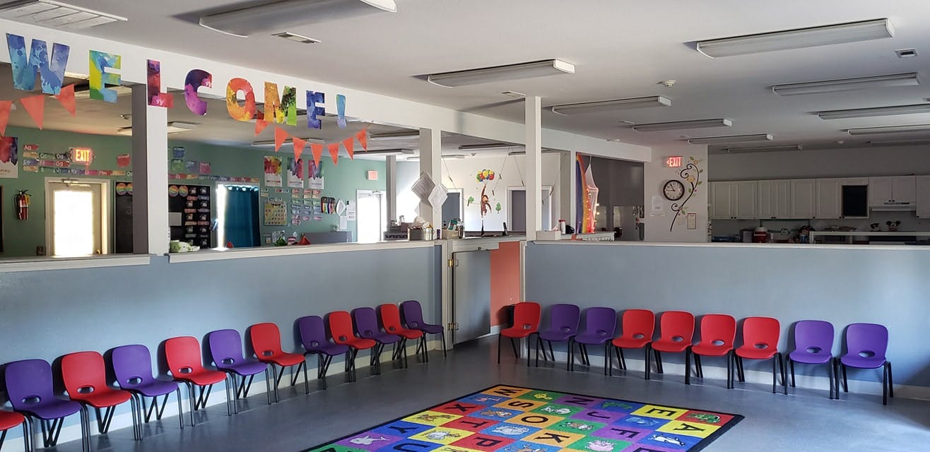 Classroom with colorful chairs and a rug with letters