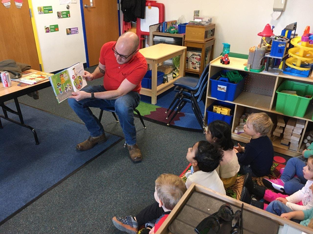 Person reading a book to children in a classroom