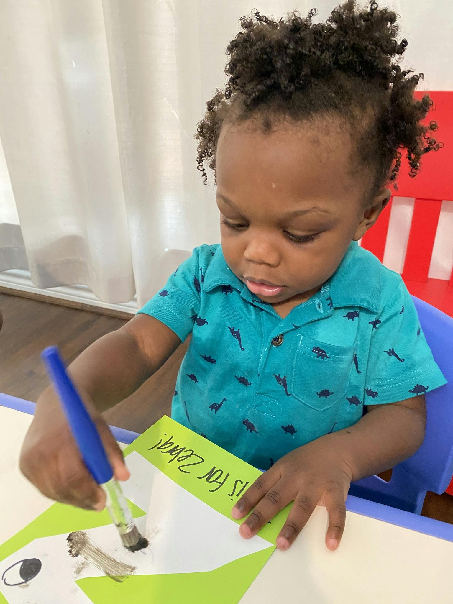 Child painting a picture of a zebra with a paintbrush