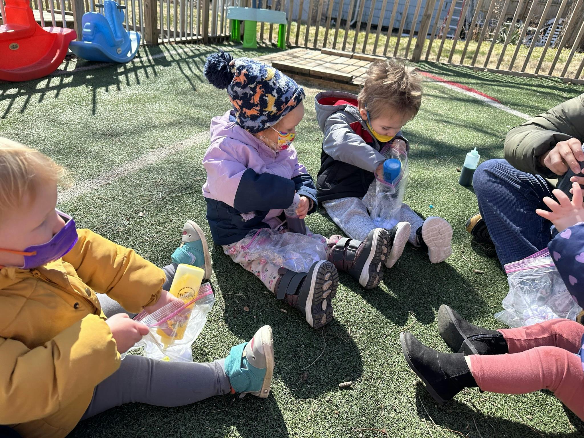 Children sitting on the ground outdoors