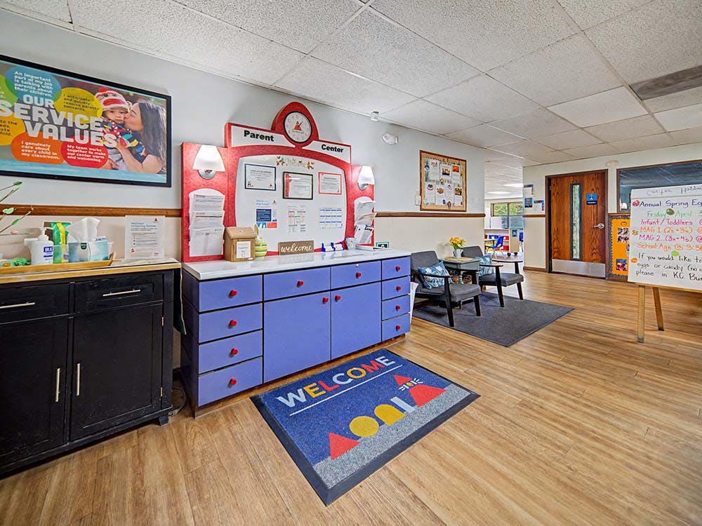 Parent information center with purple cabinets, a welcome mat, and seating area