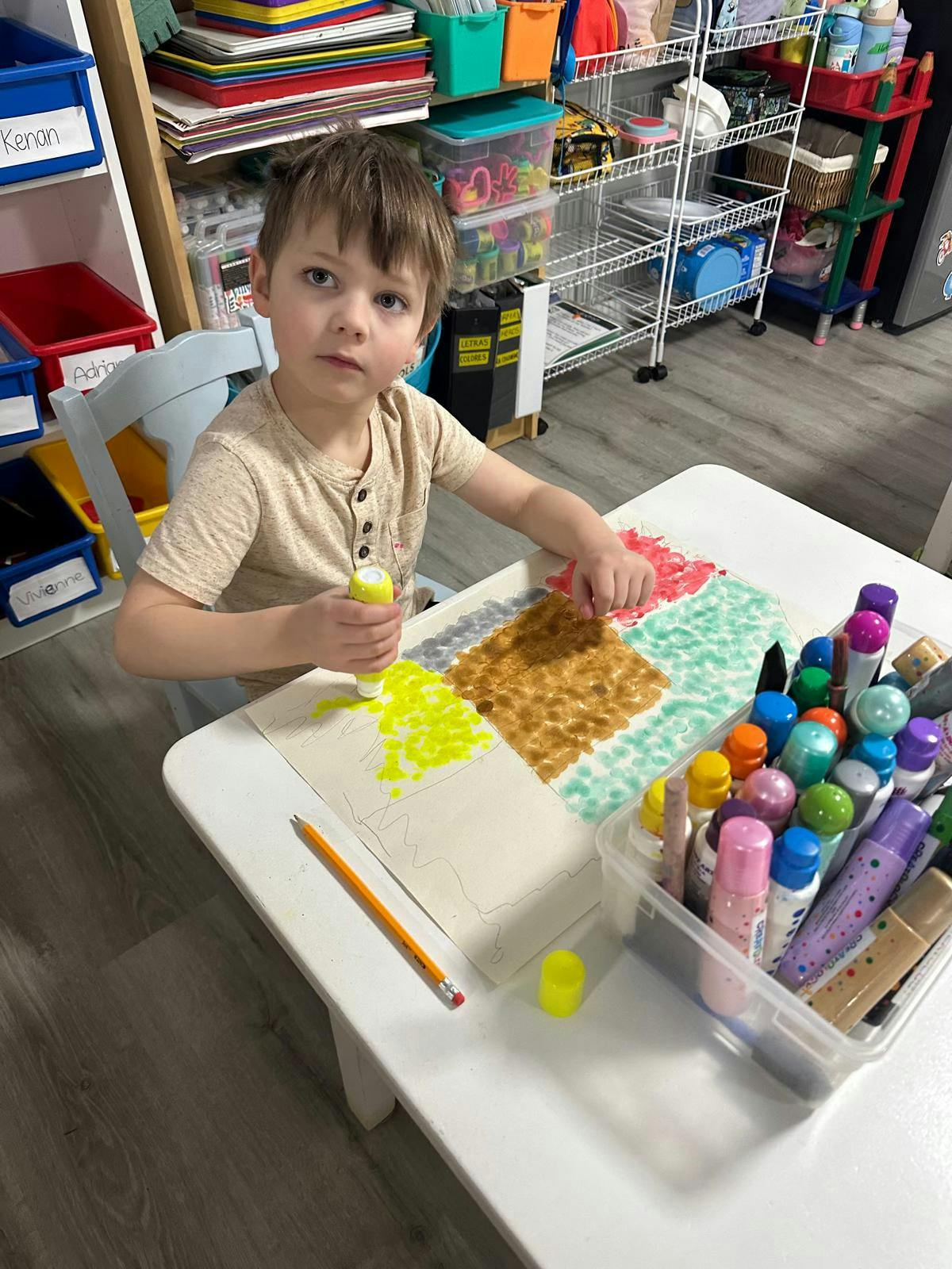 Child sitting at a table and coloring a picture