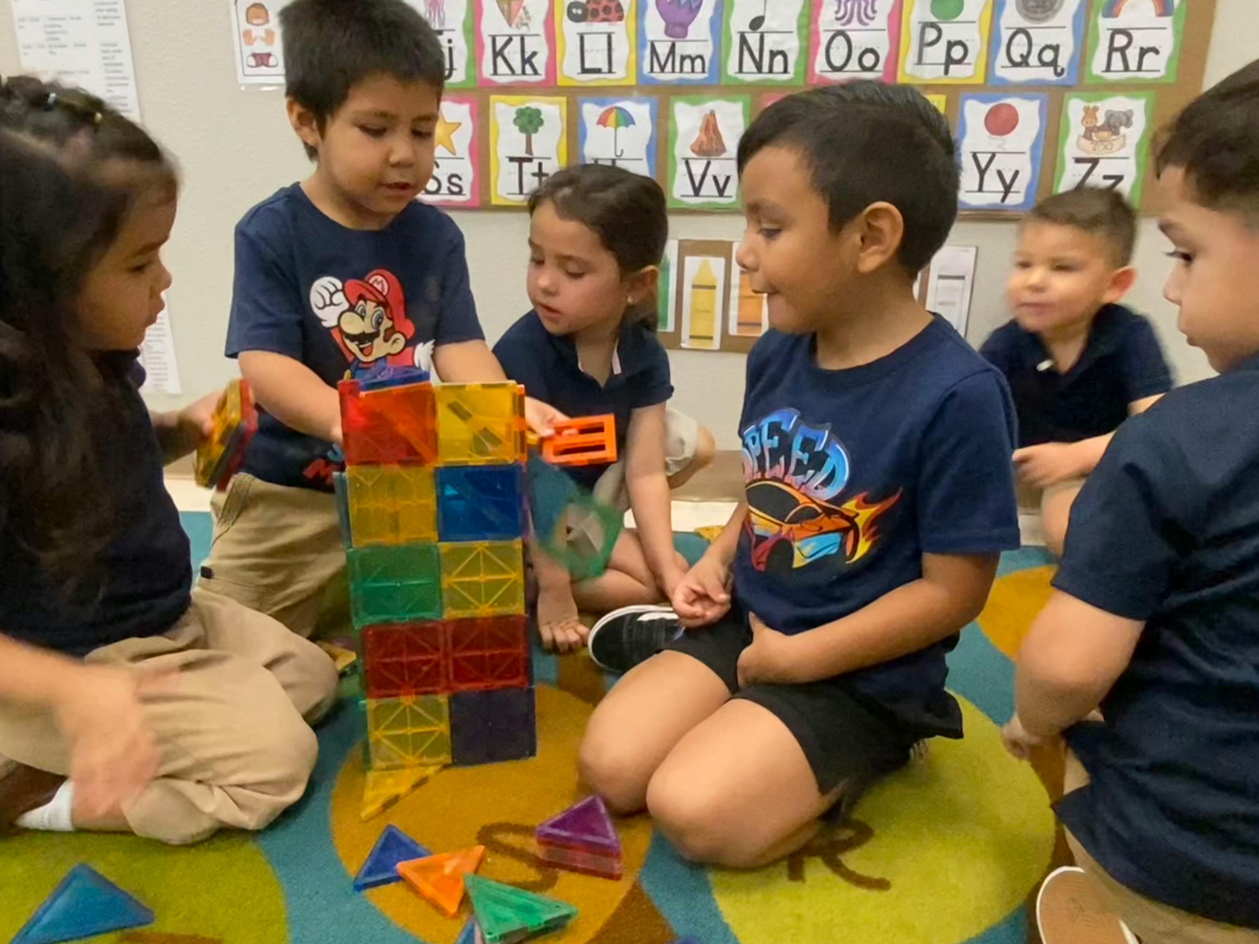 Children playing with colorful building blocks on the floor
