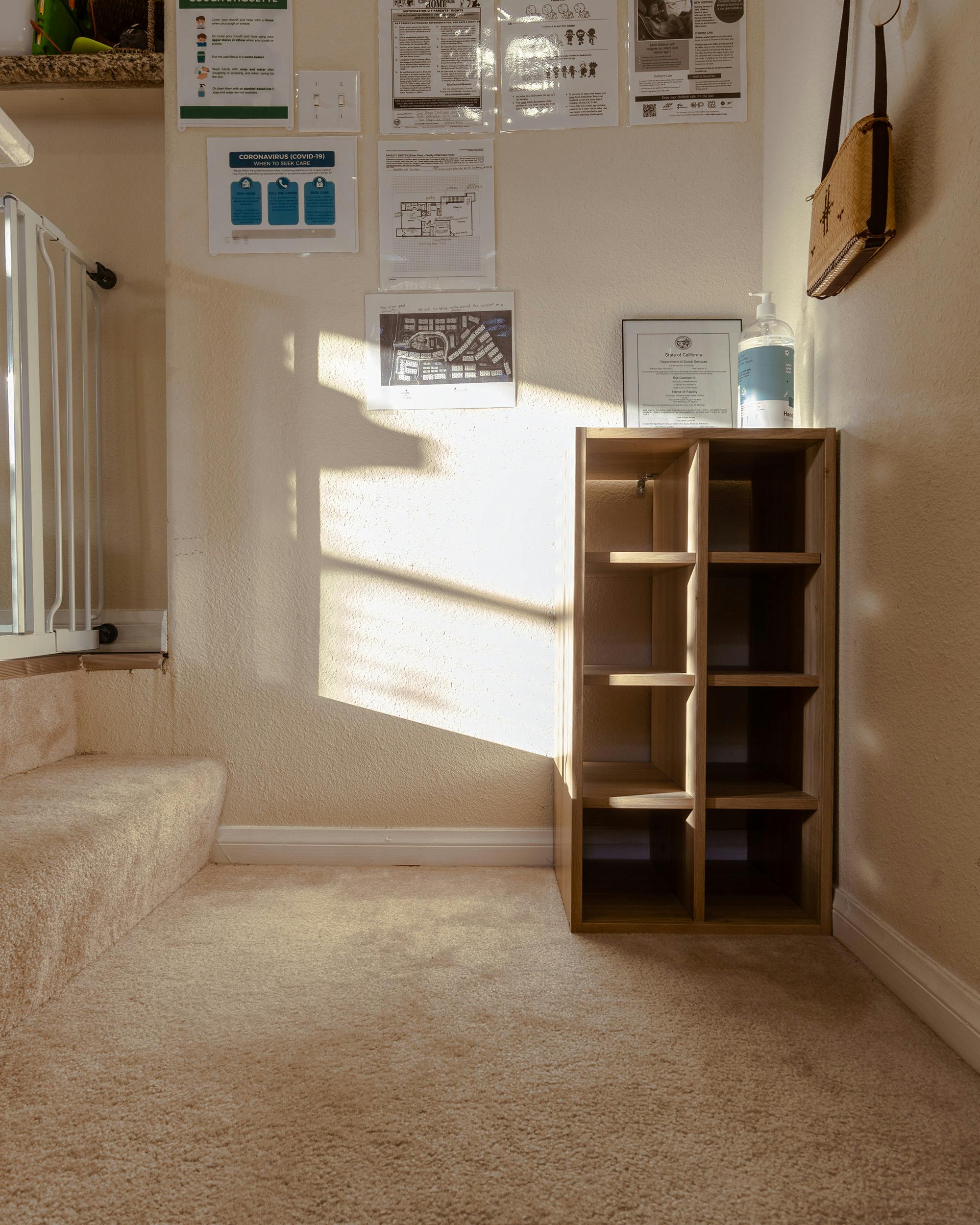 Sunlight shining on a carpeted floor next to a wooden shelf