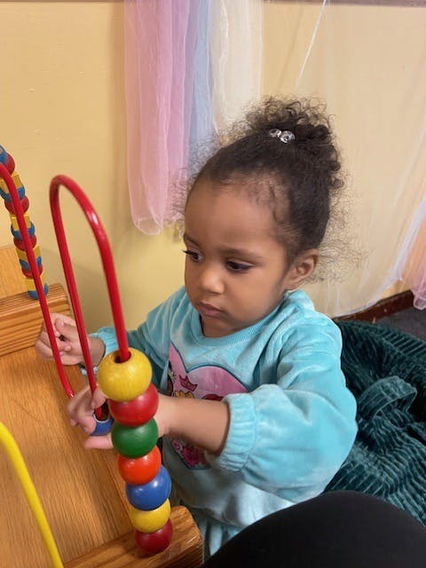 Child playing with a bead maze toy