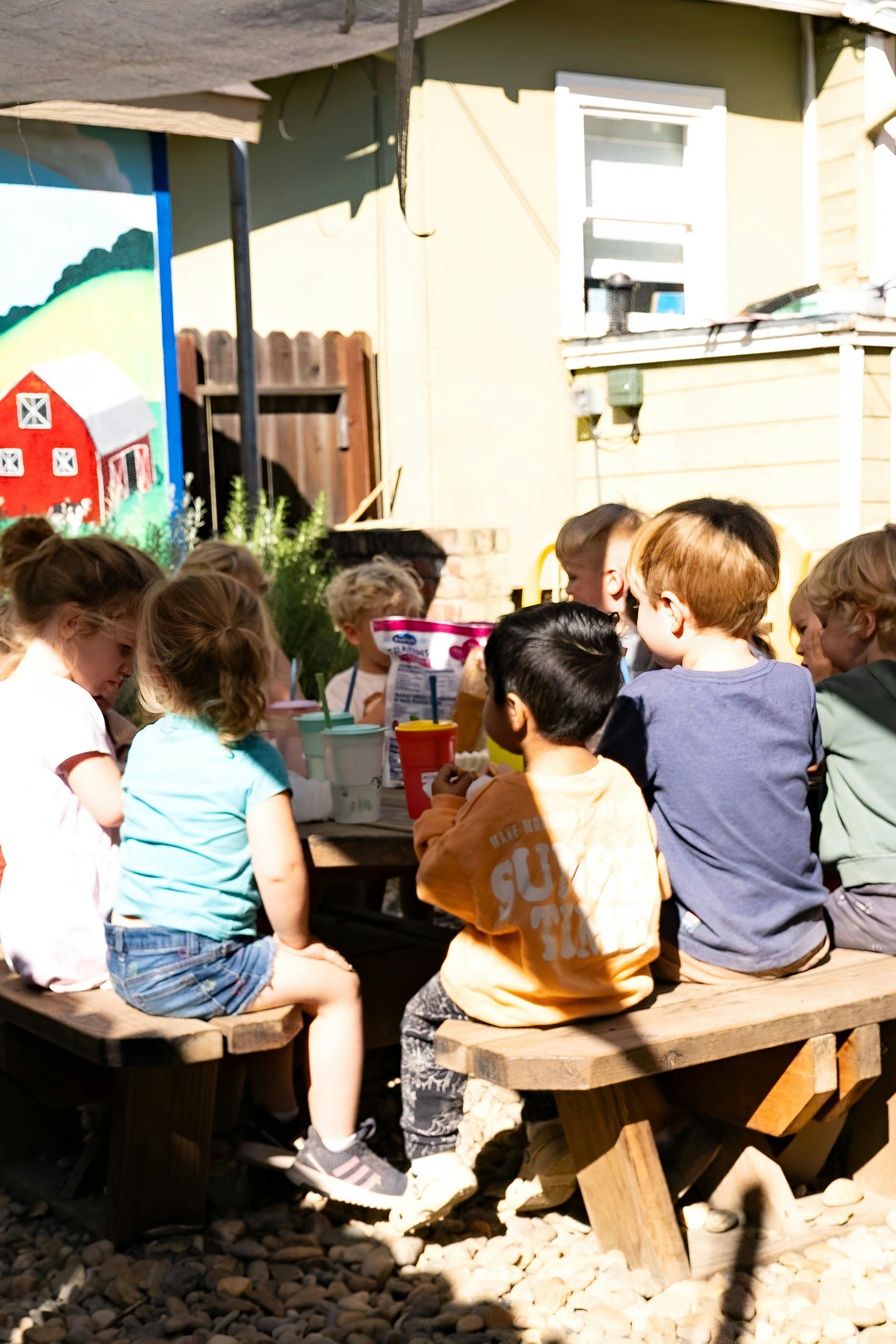 Children sitting at a picnic table outdoors