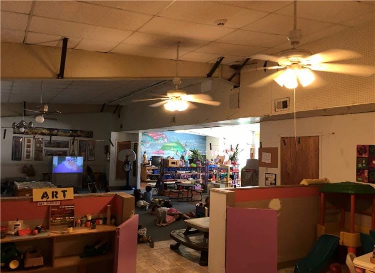 Classroom with toys, tables, and a sign that says ART