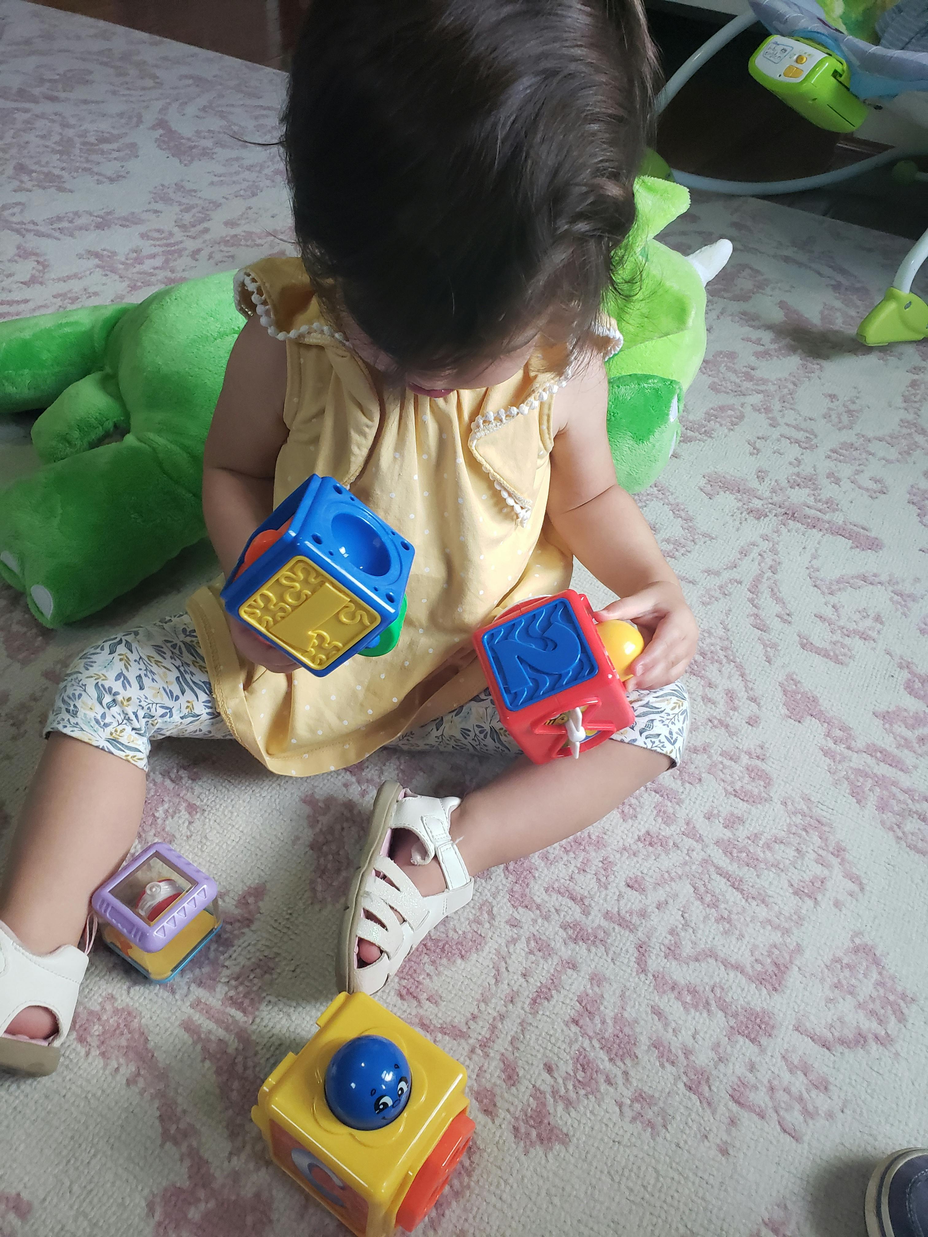 Child sitting on floor playing with colorful toy blocks