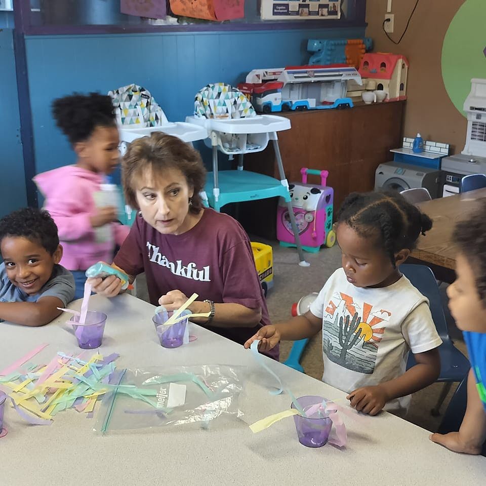 Adult and children at a table with cups and straws
