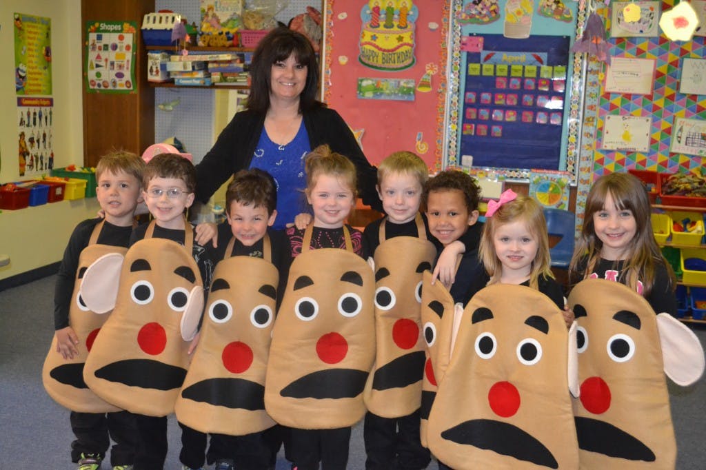 Adult and children in potato costumes in a classroom