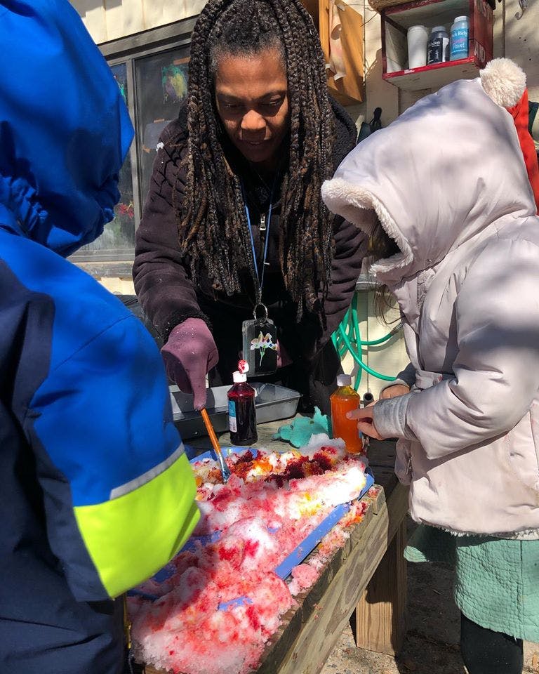 Person and two children making colored snow