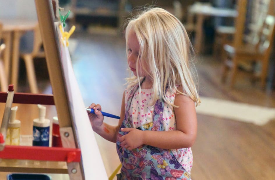 Child painting on an easel