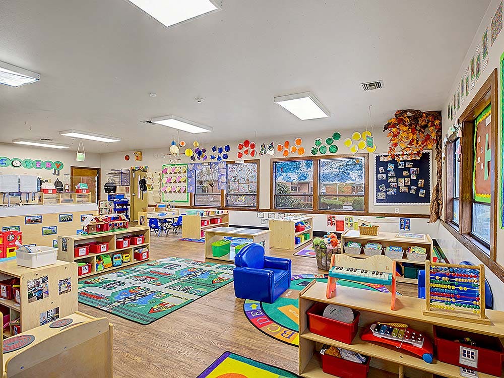 Colorful and organized classroom with toys, small tables, and rugs