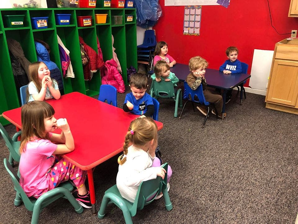 Children sitting at tables in a classroom