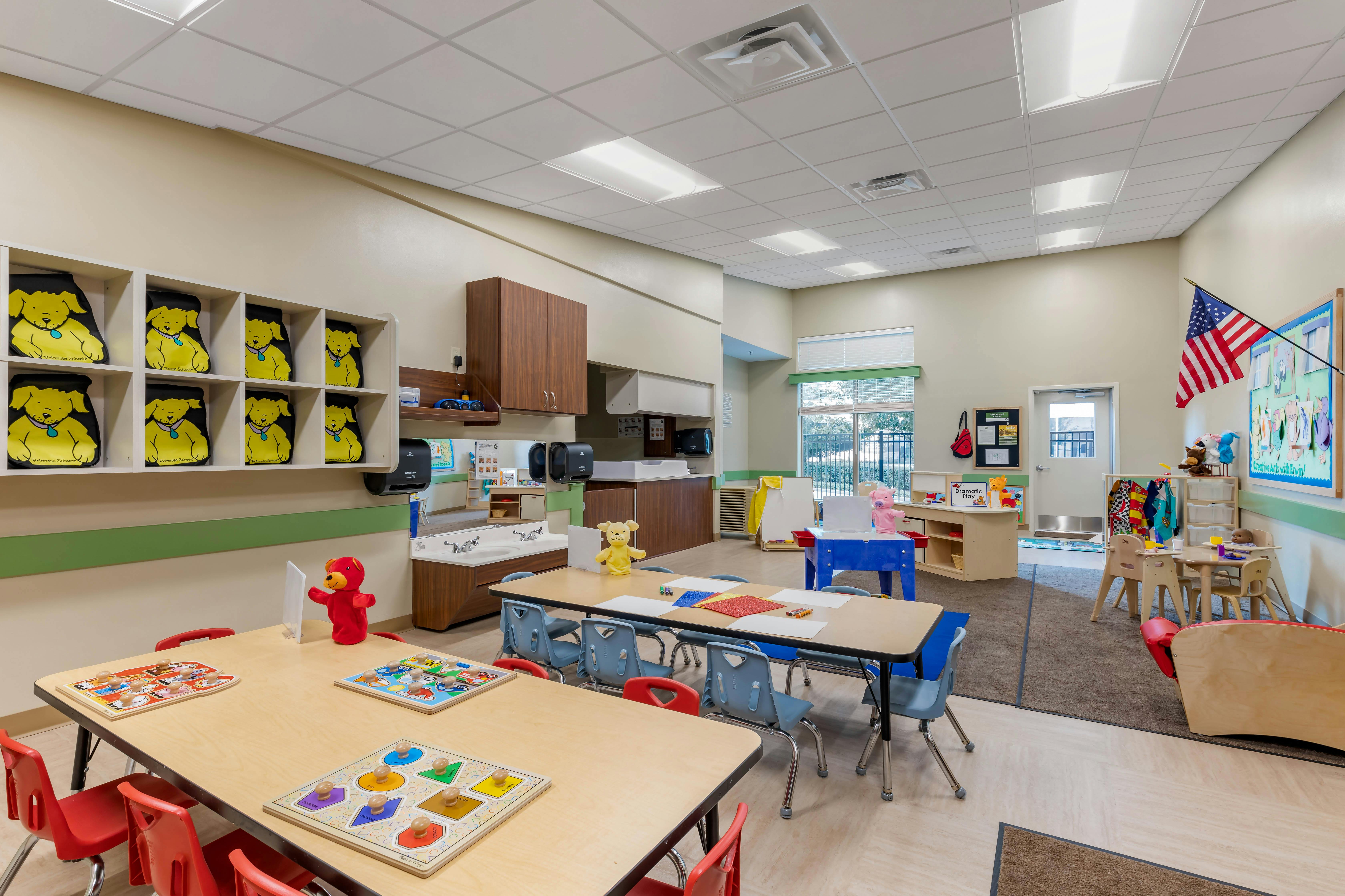 Classroom with tables, chairs, puzzles, and a changing station