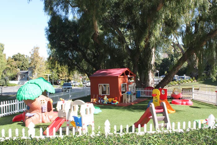 Outdoor playground with playhouses and slides on green turf