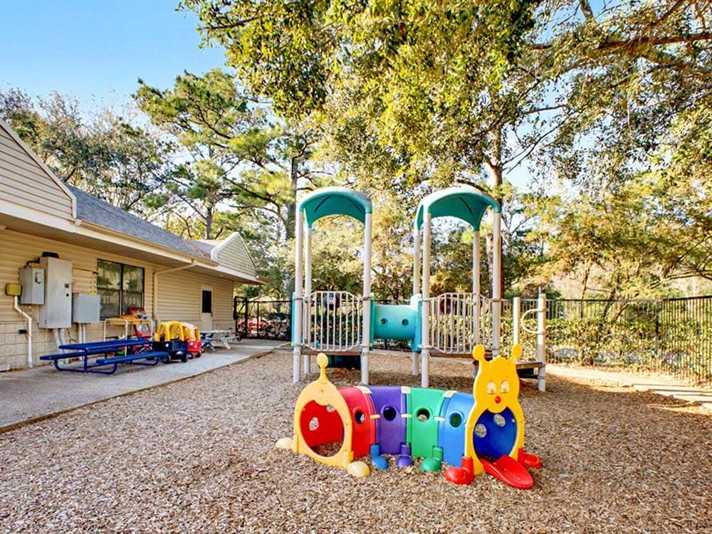 Playground with colorful caterpillar tunnel and slide structure