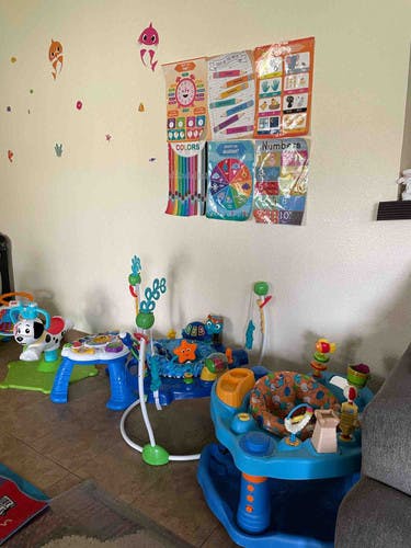 Wall with educational posters and baby toys on the floor