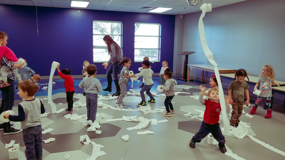 Children playing with toilet paper in a room
