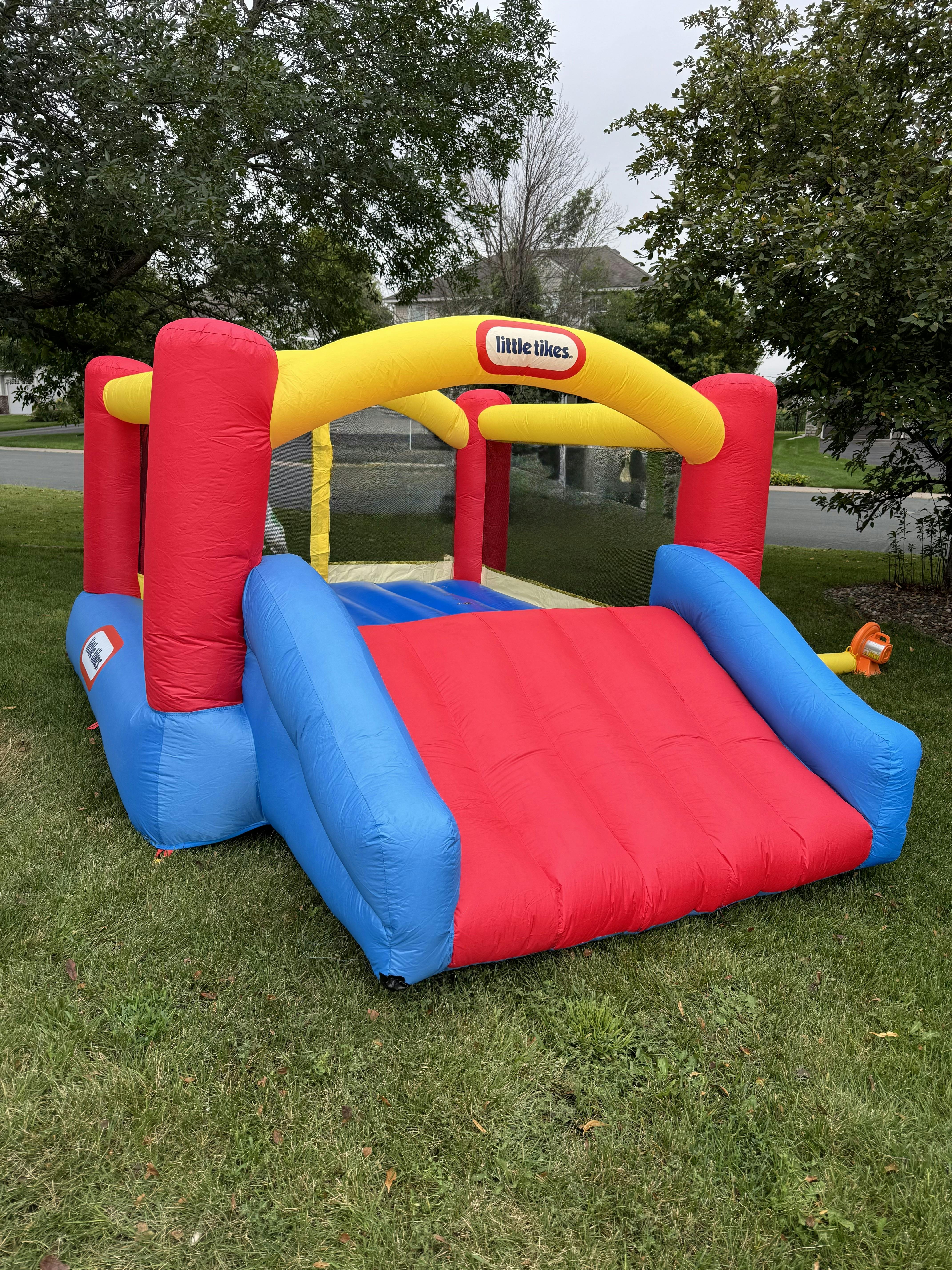 Inflatable bounce house with slide, red, blue, and yellow