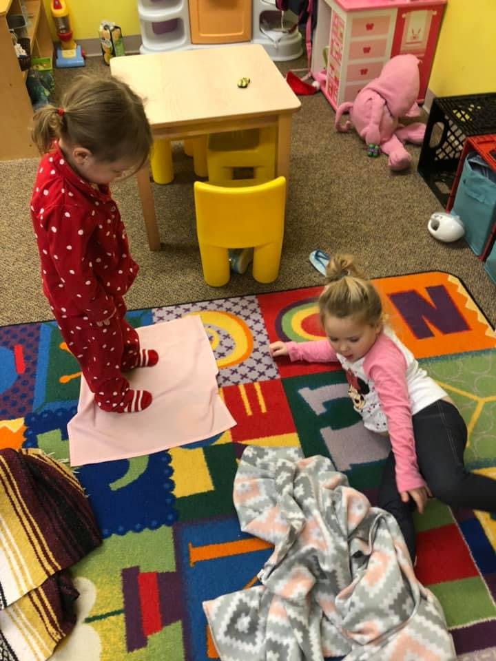 Two children playing on a colorful rug